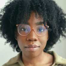 A picture of a bespectacled woman in a green dress.