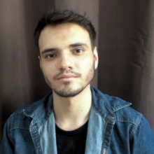 A white young man with short brown hair, brown eyes and short beard