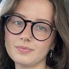 Girl with brown hair, blue eyes, and glasses. 