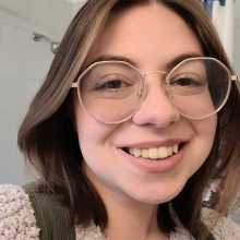 30 year old woman with brown hair and glasses. 