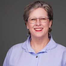 short brown hair hazel eyes wears glasses wearing blue shirt