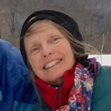 A picture of my face, smiling and wearing a black hat and a scarf.