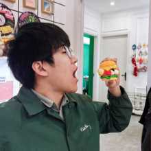 a man eating a fake hamburger