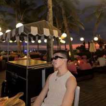 side view photo of a guy wearing black rectangle frame sunnies