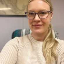 Blond woman in 30s with glasses