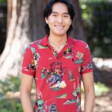 Asian American man wearing a red polo smiles
