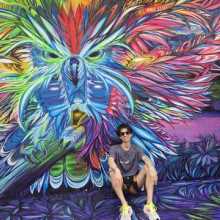 Man sitting in front of mural