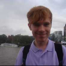 A red-haired person wearing a purple shirt