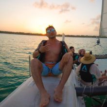 Man sitting on a boat at sunset, enjoying the ocean view