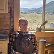 guy in front of window with cowboy hat
