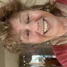 Curly brown hair, hazel eyes, big toothy grin