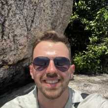 Un mec sur une pierre avec des lunettes solaires.