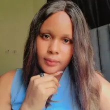 Friendly portrait of a woman in a blue top, posing indoors.