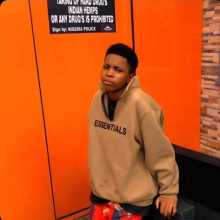 Profile photo of a person indoors with an orange background.