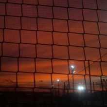 Picture of  a sunset in a football field 