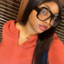 Selfie portrait of a girl in a reddish-orange shirt.