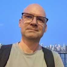Just some bald dude with a wonky smile