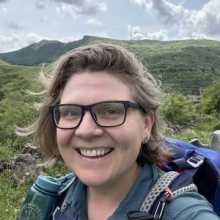 Smiling woman in hiking gear.