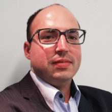 Headshot photo of Thiago Coelho wearing glasses and a suit jacket
