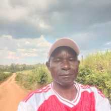 “A friendly Kenyan man smiling warmly for a profile photo.”