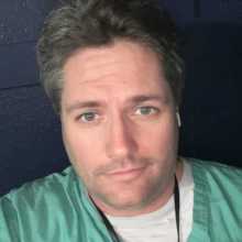 6’6 inch man in medical scrubs.