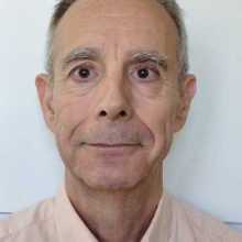 Retrato de Enrico sonriendo frente a la cámara.