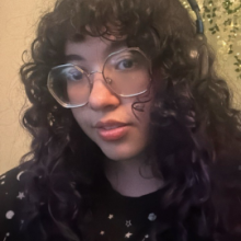 I am a girl with dark brown curly hair, dark brown eyes, big hexagonal glasses and white skin