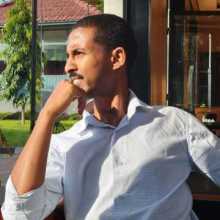 Friendly portrait of a man sitting by a window and looking outside