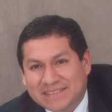 A smiling man wearing a suit and white shirt.